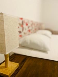 マラウにあるFlat Iansã Condomínio beira-mar Varanda Piscina.のベッド上にランプ付きの木製テーブル