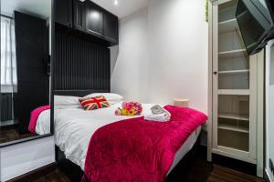 ein Schlafzimmer mit einem Bett mit einer rosa Decke in der Unterkunft Stylish 2 bedroom apartment in Shoreditch - London in London