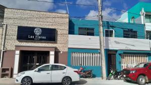 a white car parked in front of a building at Hotel Las Flores Campeche in Campeche