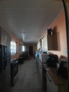 a room with a kitchen with a long hallway at Pousada Ana in São Gabriel +3 photos