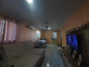 a bedroom with a bed and a tv and a table at Pousada Ana in São Gabriel