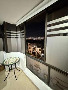 Un balcón con una mesa y vista a una ciudad. en Habitacion Multiple con baño privado, en Medellín