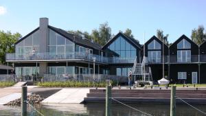 a large black house with a balcony on the water at Hotel Strandtangen in Skive