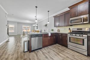 a kitchen with stainless steel appliances and wooden cabinets at Garage w/ Veranda & Washer + Dryer in Atlanta
