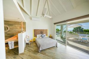 a bedroom with a bed and a balcony at VILLADO LUXURY - sint marteen in Dawn Beach +63 photos