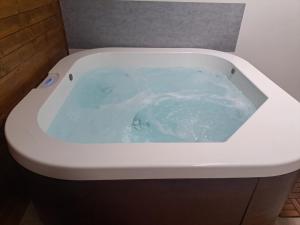 a white bath tub with blue water in it at Kuča za odmor Stina in Slavetić +34 photos