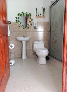 un baño con inodoro y lavabo en SimpleSerenity Country House, en Juayúa