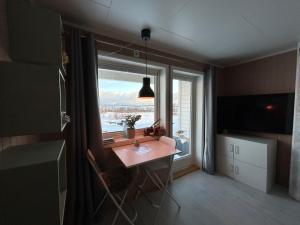 トロムソにあるKvaløya Arctic Retreat - Room in Beautiful Kvaløya, Tromsøのデスク、大きな窓が備わる客室です。