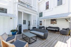 une terrasse en bois avec des canapés et des chaises. dans l'établissement Deluxe King - Curry Mansion with Pool!, à Key West 21 autres photos