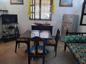 a dining room with a table and chairs and a couch at Karibuni in Malindi
