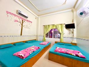 two beds in a room with a window at Nhà Nghỉ in áº¤p VÄ©nh ÃÃ´ng