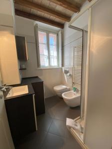 Un baño con lavabo, inodoro y ventana. en Casa Fabrizio - Nice Suite con parcheggio su richiesta, en Parma 1 foto más