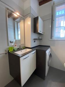 una cocina con fregadero y lavadora en Casa Fabrizio - Nice Suite con parcheggio su richiesta, en Parma
