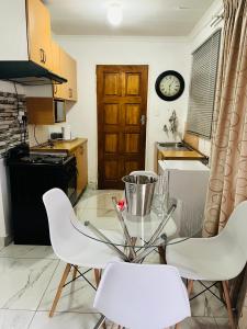a kitchen with a table and chairs and a clock at Mohwelere Guest House in Pretoria