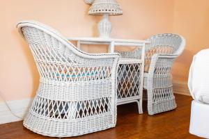2 sillas blancas de mimbre y una mesa con lámpara en King Suite at Curry Mansion with Heated Pool!, en Key West