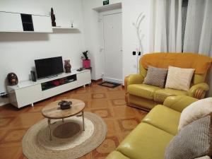 a living room with a yellow couch and a table at Casa da Calçada - Casa Inteira in Seia