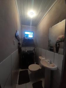 a bathroom with a sink and a toilet and a mirror at Pousada Ana in São Gabriel
