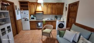 eine Küche mit einem blauen Sofa und eine Küche mit einem Kühlschrank in der Unterkunft La casita de Mar in Castril + 24 Fotos