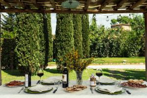 une table avec des verres de vin et des assiettes de nourriture dans l'établissement La Pergola, à Lucignano