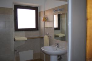 un bagno con lavandino e specchio di Corallo Aparment a Cala Gonone
