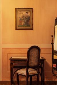 une table avec une chaise et un tableau sur le mur dans l'établissement La Pergola, à Lucignano