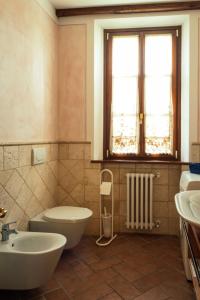 une salle de bain avec toilettes, lavabo et fenêtre dans l'établissement La Pergola, à Lucignano