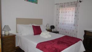 a bedroom with a bed with a red and white blanket at Casa da Calçada - Piso 1 in Seia