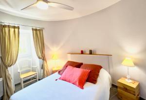 een slaapkamer met een wit bed met rode kussens bij Gîtes Château de la Selve in Grospierres +55 foto's