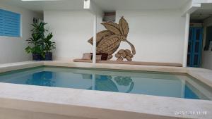 a swimming pool in a house with a butterfly on the wall at Hotel cacao spa cozumel in Cozumel