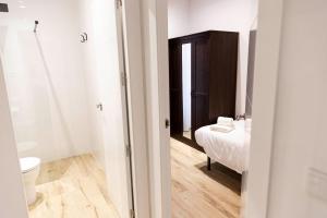 Un baño con inodoro y una cama en una habitación. en Apartamentos Julio Burell, 74, en Linares 37 fotos más