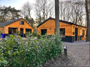 a wooden house with a sign in front of it at Het Sterrenbos in Zuidwolde