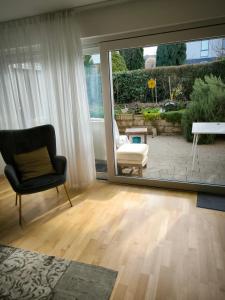 a living room with a chair and a window at Weinbergblick in Kirchheim am Neckar