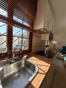 a kitchen with a stainless steel sink and a window at Apto con vistas Virgen del Carmen in El Rompido +16 photos