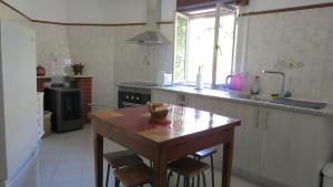 a kitchen with a wooden table and a counter top at Casa da Calçada - Piso 2 in Seia