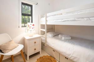 a bedroom with two bunk beds and a chair at Villa V2 VALE DO LOBO BEACH & GOLF in Vale do Lobo