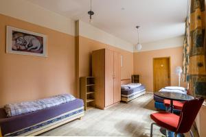 a room with two beds and a table and chairs at Enjoy your stay with DKN apartments - Mon-Sun - Late night check-in - Multilanguage - Near Railway station - Witamy serdecznie in Halle an der Saale