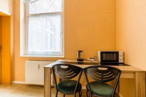 a kitchen with a table with two chairs and a microwave at Enjoy your stay with DKN apartments - Mon-Sun - Late night check-in - Multilanguage - Near Railway station - Witamy serdecznie in Halle an der Saale