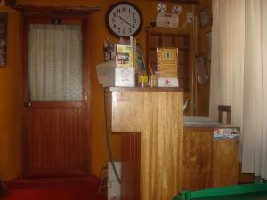 a wooden desk with a clock on top of it at Samay Wasi Hostel I in Cusco