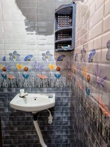 baño con lavabo y flores en la pared en Smiley HomeStay at Chidambaram, en Chidambaram