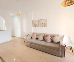 a living room with a couch with pillows on it at Apartamento con Piscina, Parque las Naciones, Torrevieja in Torrevieja