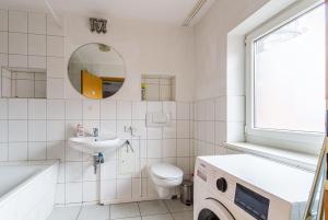 a bathroom with a sink toilet and a mirror at Enjoy your stay with DKN apartments - Mon-Sun - Late night check-in - Multilanguage - Near Railway station - Witamy serdecznie in Halle an der Saale +13 photos