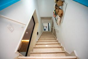 a staircase in a house with white walls and wooden stairs at Arco di Luna Piano 2 in Trani