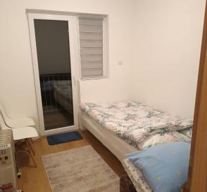 una piccola camera da letto con un letto e una finestra di Apartman Iva a Kupres