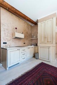a kitchen with white cabinets and a red rug at Apartment Piazza in Rovinj
