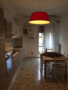 una cucina con tavolo e lampada rossa di Casa Farinati 3 a Verona