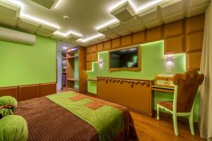 a bedroom with a bed and a desk and a tv at Chocoland Hotel Gramado in Gramado