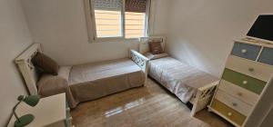 a small bedroom with two beds and a window at Casa familiar con doble patio, cochera, fácil acceso en el centro de Escobar in Belén de Escobar