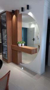 a mirror in a room with two potted plants at Lindo apartamento próximo do mar novinho in Bombinhas