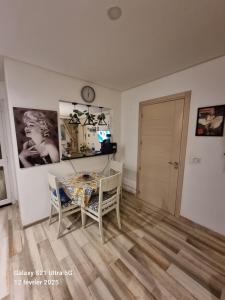 a living room with a table and chairs and a clock at Ghamarth Mikonos in Gammarth +2 photos