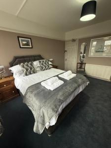 a bedroom with a large bed with two towels on it at The Endeavour in Whitby